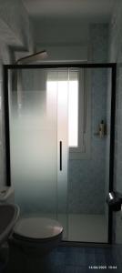baño con ducha, aseo y ventana en Apartamento-Casa Los Cuadrillos, en Noja