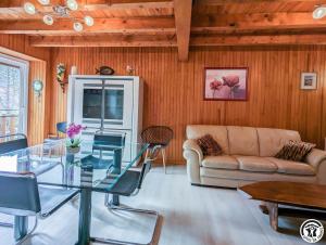 een woonkamer met een glazen tafel en een bank bij Au cabanous in Boutx