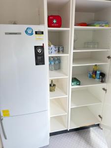 - un réfrigérateur-congélateur blanc installé à l'intérieur de la cuisine dans l'établissement Central Sandy Bay Retreat, à Sandy Bay 2 autres photos