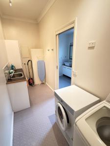 - une buanderie avec un lave-linge et un évier dans l'établissement Central Sandy Bay Retreat, à Sandy Bay