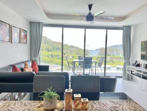 a living room with a couch and a ceiling fan at Twin Sands Resort Penthouse in Patong Beach