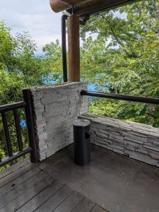 a porch with a trash can on a wooden deck at エメラルドグリーン富士 in Atami
