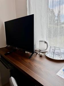 a flat screen tv sitting on top of a wooden desk at Sunrise Apartments in Jūrmala +73 photos