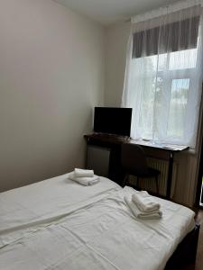 a bedroom with a bed and a desk with a computer at Sunrise Apartments in Jūrmala