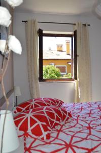 sypialnia z czerwonym łóżkiem i oknem w obiekcie Apartment Bozac w Rovinj