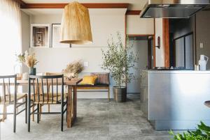 a kitchen and dining room with a table and chairs at マイグレフラット in Ito