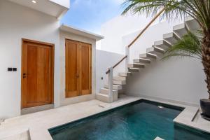 a swimming pool in a house with a staircase at Enaya Villa by Betterplace in Tumbak Bayuh +16 photos