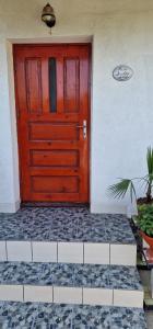 Una puerta roja en un edificio con suelo de baldosas. en Casa Dorului, en Mangalia