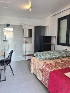 PezensにあるCharmante villa à Pezensのベッドとテーブルと椅子のある寝室