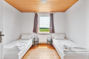 two beds in a room with a window at GÜNSTIGE Wohnungen für Monteure in Suppingen-Laichingen TV,Wifi,Parking in Laichingen