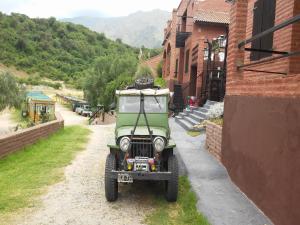a green jeep parked next to a building at La Loma Resort in Merlo +63 photos
