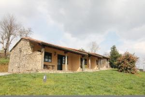 a stone house in a field with a yard at Casa do Cura in Beigondo