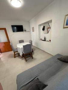 a living room with a table and chairs and a tv at Bobo App in Senj