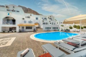 a villa with a swimming pool in front of a building at Elea Sun Hotel in Kamari
