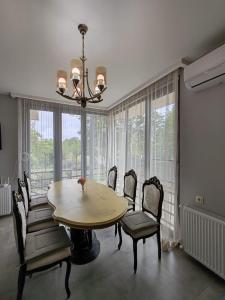 a dining room with a table and chairs and windows at Vakho house - first floor in Urekis Sadguri +29 photos