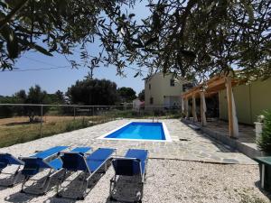 a pool with lounge chairs and a house at Kefalonia Olive House private pool in Xi