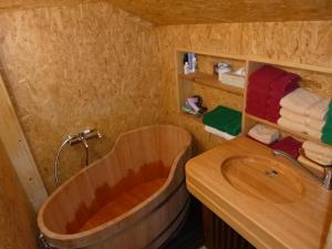 ein Badezimmer mit einer Holzbadewanne und einem Waschbecken in der Unterkunft Waldhütte in Hochpillberg