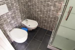 La salle de bains est pourvue de toilettes, d'un lavabo et d'une douche. dans l'établissement Affittacamere Casa Brajan, à Follonica
