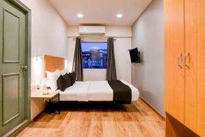 a hotel room with a bed and a window at Townhouse Oak VIP Road NSCB Airport in kolkata