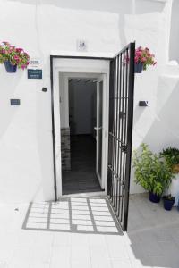 an open door in a white building with potted plants at La casita de Paco in Barbate
