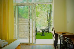 a room with a window and a table and chairs at Chester Oak Kasauli - Premium rooms and Exclusive Villa in Kasauli