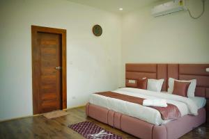 a bedroom with a large bed with a wooden headboard at Chester Oak Kasauli - Premium rooms and Exclusive Villa in Kasauli