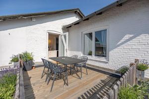 a wooden deck with a table and chairs on it at Ferienwohnung Alte Meierei in Gelting