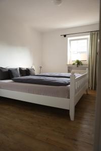 a white bed in a white bedroom with a window at Ferienwohnung Sepp in Inzell