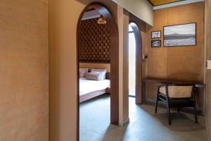 a bedroom with a bed and a table with a chair at Asmi Villa in Kolāra +10 photos