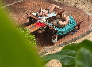 two women in bathing suits laying on a picnic table at Canaan Beach Home in Phú Quốc