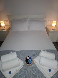 a bedroom with a white bed with towels and a bowl of pillows at La casita de Paco in Barbate