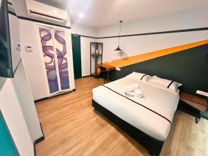 八打灵再也Seeds Hotel Damansara Pelangi的卧室配有一张白色大床和一张书桌