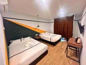 八打灵再也Seeds Hotel Damansara Pelangi的有两张床和一张书桌的酒店房间