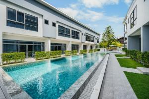 an external view of a building with a swimming pool at RYANNA Samui in Choeng Mon Beach