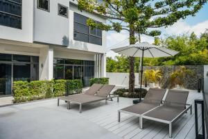 a patio with two chairs and an umbrella at RYANNA Samui in Choeng Mon Beach