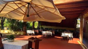 a patio with a large umbrella and tables and chairs at Hotel Solari in Briatico