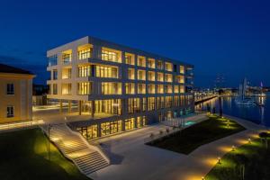ein großes Gebäude mit Lichtern vor einem Wasserkörper in der Unterkunft Monumenti Heritage Hotel&Resort in Pula