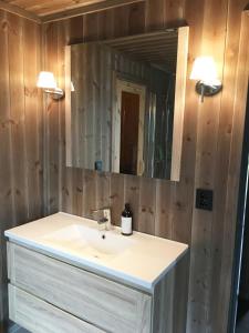 un baño con lavabo y espejo en High standard Cabin close to Norefjell,  57 fotos más