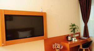 a large flat screen tv hanging on a wall at GreenTree Inn LangFang YanJiao Tianyang Plaza Express Hotel in Gaolou