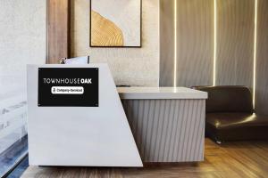 a desk with a sign on it next to a chair at Townhouse Oak Pachamarhi Lake in Pachmarhī