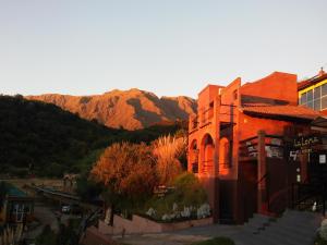 a red brick building with mountains in the background at La Loma Resort in Merlo