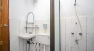 une salle de bain blanche avec un lavabo et une douche dans l'établissement OYO 89537 Fairy Garden Resort, à Kampong Kinasaraban 51 autres photos