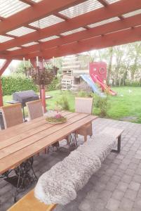 una mesa de madera y sillas en un patio con parque infantil en Übernachtung im Bauwagen, en Stedesdorf