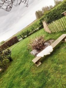 un banco de madera sentado en el césped en un campo en Übernachtung im Bauwagen, en Stedesdorf