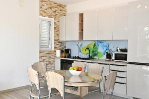 a kitchen with a table with a bowl of fruit on it at Holiday Home Chill Zone in Baška Voda