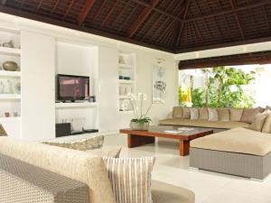 a living room with a couch and a table at Villa Asante in Canggu