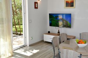 a dining room with a table and a television on a wall at Holiday Home Chill Zone in Baška Voda