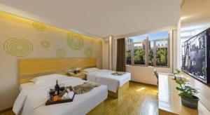 a hotel room with two beds with a tray of food at GreenTree Inn Huangshi Huahu Development Zone Daquan Road in Huangshi