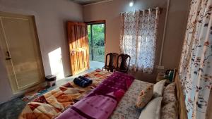a bedroom with a bed in a room with a window at Cozyo Stays Boutique Cabin Mawlynnong in Mawlynnong +6 photos