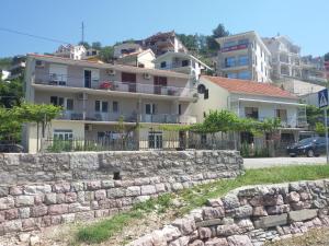 una pared de piedra frente a un edificio en Apartmani Ivana, en Tivat